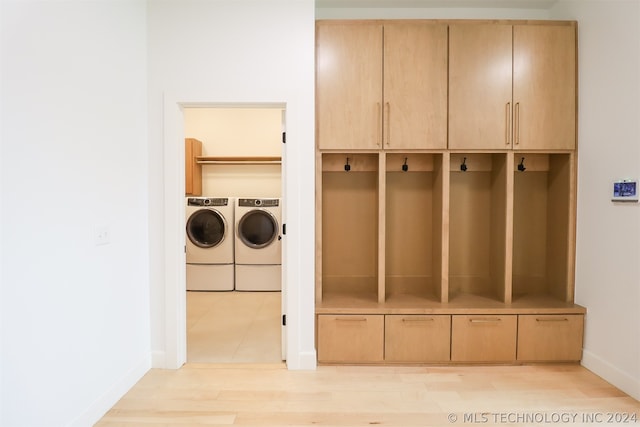 mudroom featuring independent washer and dryer and light hardwood / wood-style floors