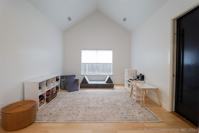 misc room with high vaulted ceiling and light wood-type flooring