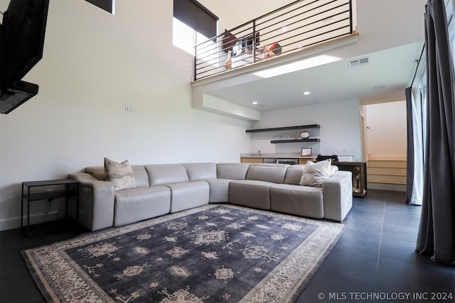 living room featuring dark tile patterned floors and a towering ceiling