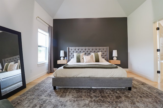 bedroom featuring light hardwood / wood-style floors and vaulted ceiling