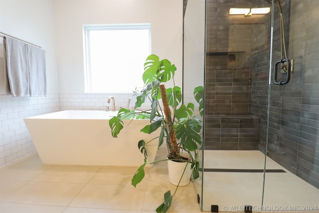 bathroom featuring independent shower and bath, tile patterned floors, and tile walls