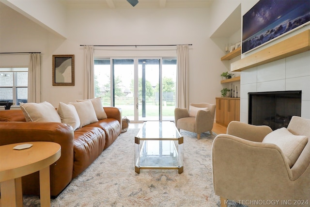 living room featuring a tile fireplace and a towering ceiling