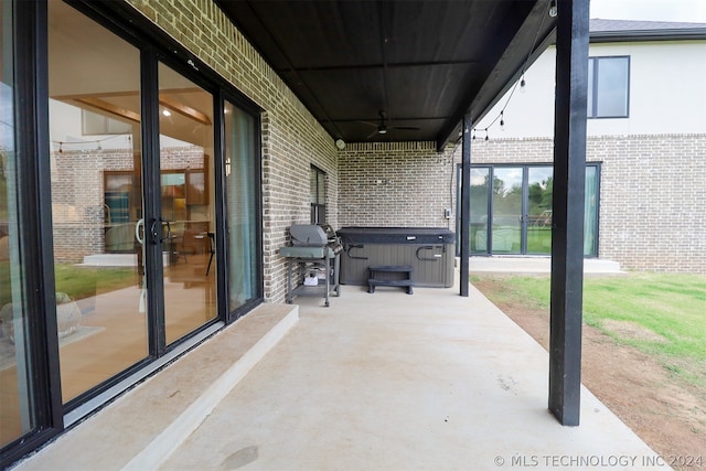 view of patio / terrace featuring a hot tub, ceiling fan, and a grill