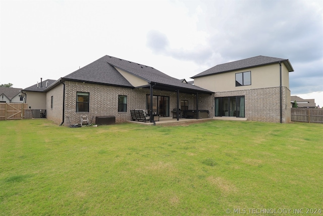 rear view of house with a patio area, central air condition unit, and a yard