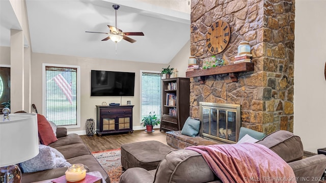 living room featuring hardwood / wood-style flooring, high vaulted ceiling, ceiling fan, and a fireplace