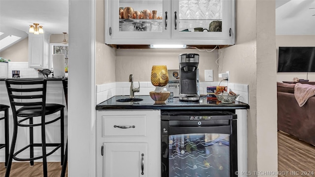 bar featuring white cabinetry, beverage cooler, and wood-type flooring