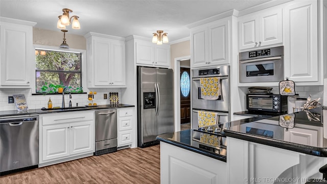 kitchen featuring light hardwood / wood-style floors, white cabinetry, decorative backsplash, sink, and stainless steel appliances