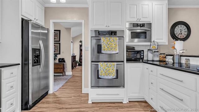 kitchen featuring white cabinetry, appliances with stainless steel finishes, and light wood-type flooring