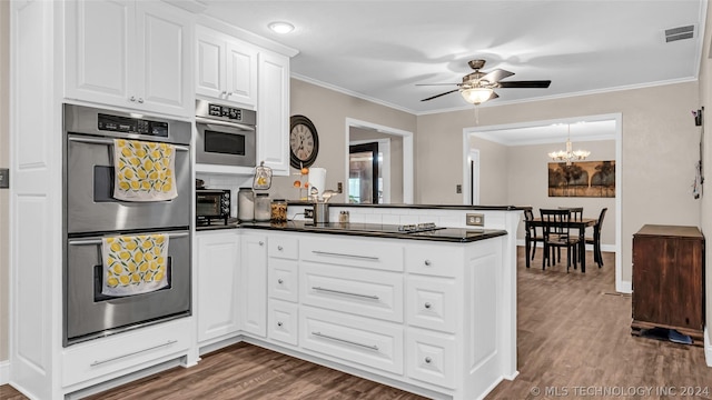 kitchen featuring ceiling fan with notable chandelier, stainless steel double oven, white cabinets, kitchen peninsula, and black electric cooktop