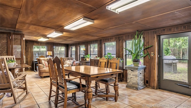 dining room with wood ceiling, wood walls, and plenty of natural light