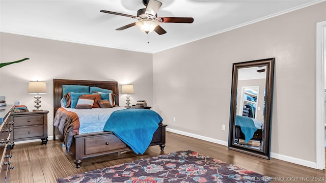 bedroom with crown molding, dark hardwood / wood-style floors, and ceiling fan