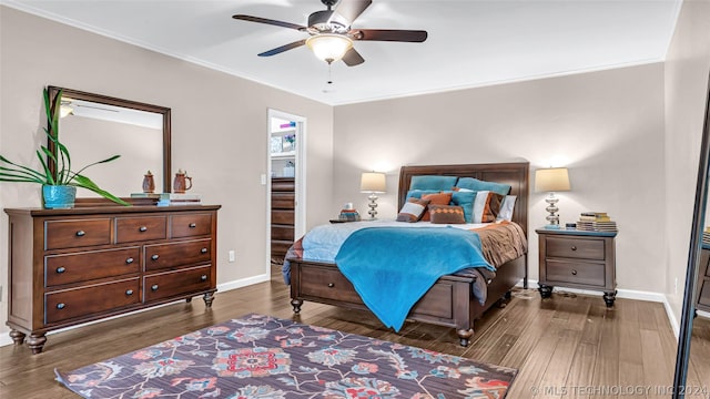 bedroom with dark wood-type flooring, ceiling fan, and ornamental molding