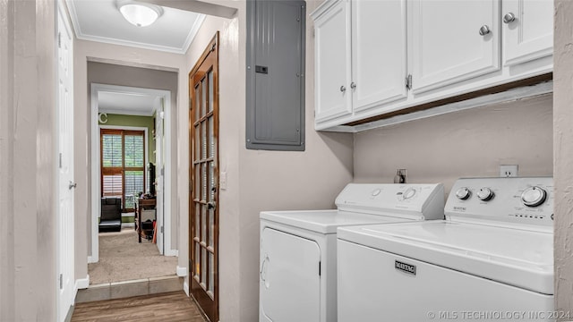 washroom with washing machine and dryer, electric panel, ornamental molding, and cabinets