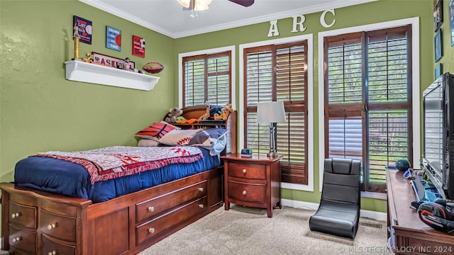 carpeted bedroom featuring ceiling fan and ornamental molding