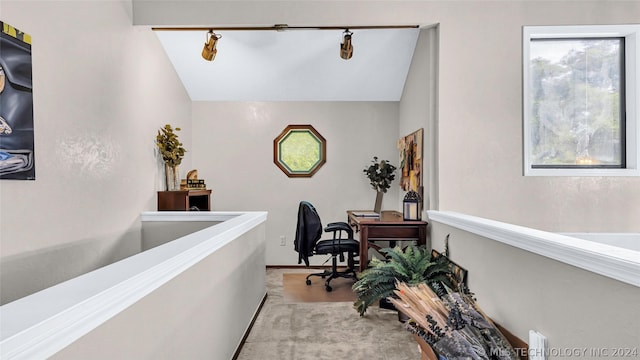 office area featuring light carpet, lofted ceiling, and track lighting