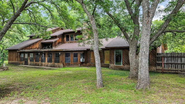 back of house with a sunroom and a lawn