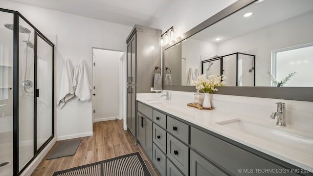 bathroom featuring a shower with door, vanity, and hardwood / wood-style floors