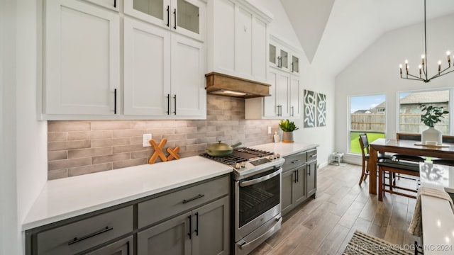 kitchen with white cabinetry, vaulted ceiling, gray cabinetry, decorative light fixtures, and stainless steel gas range