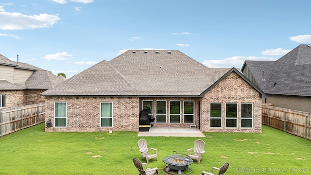 back of property with a patio area, a lawn, and a fire pit