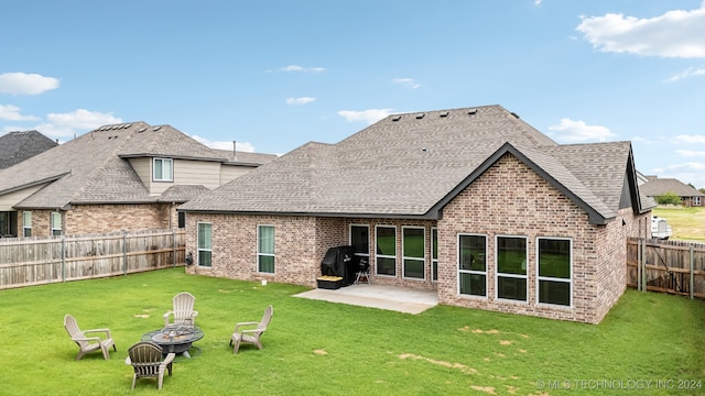 back of house with a patio, a fire pit, and a lawn