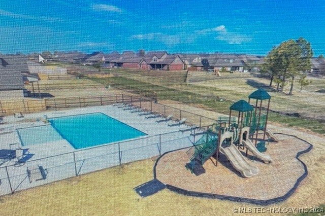 view of swimming pool with a playground