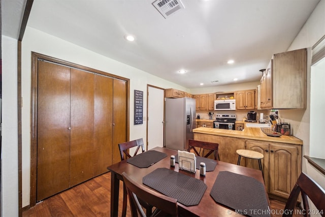 dining space with dark hardwood / wood-style flooring and sink