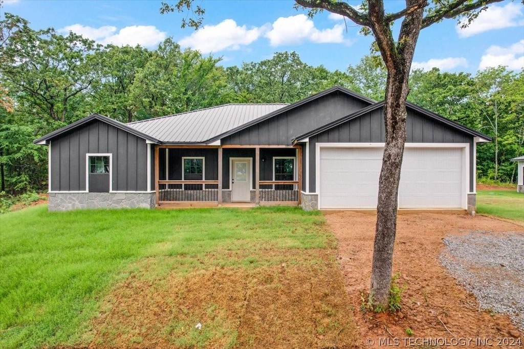 ranch-style house featuring a garage, a front yard, and a porch