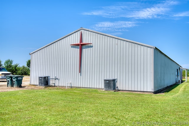 view of outdoor structure with cooling unit and a lawn