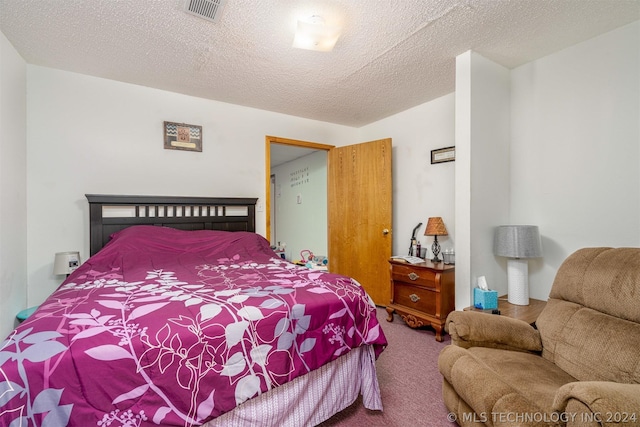 bedroom featuring a textured ceiling and carpet flooring