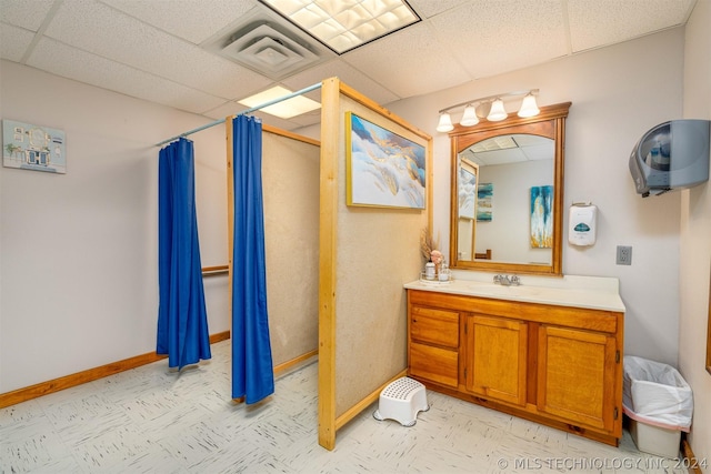 bathroom with a drop ceiling, vanity, and a shower with shower curtain