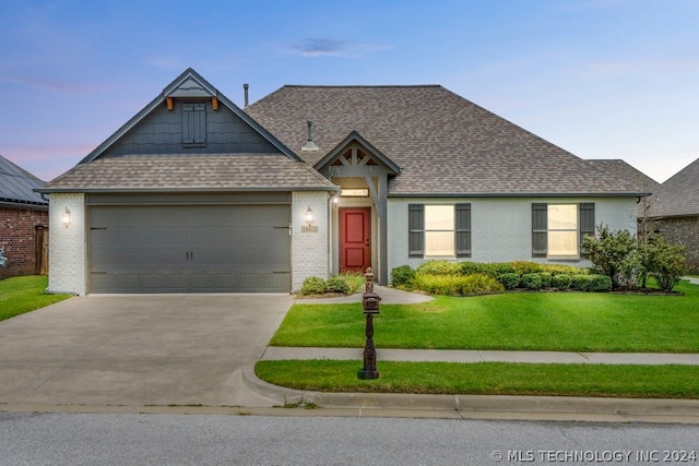 view of front of property featuring a garage and a lawn