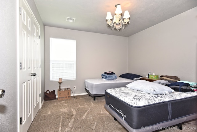 carpeted bedroom featuring an inviting chandelier