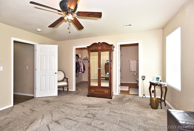 bedroom featuring ensuite bath, carpet flooring, a walk in closet, and ceiling fan