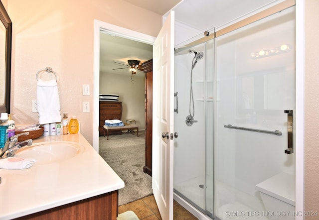 bathroom with vanity, a shower with shower door, tile patterned flooring, and ceiling fan