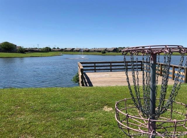 view of dock with a water view and a lawn