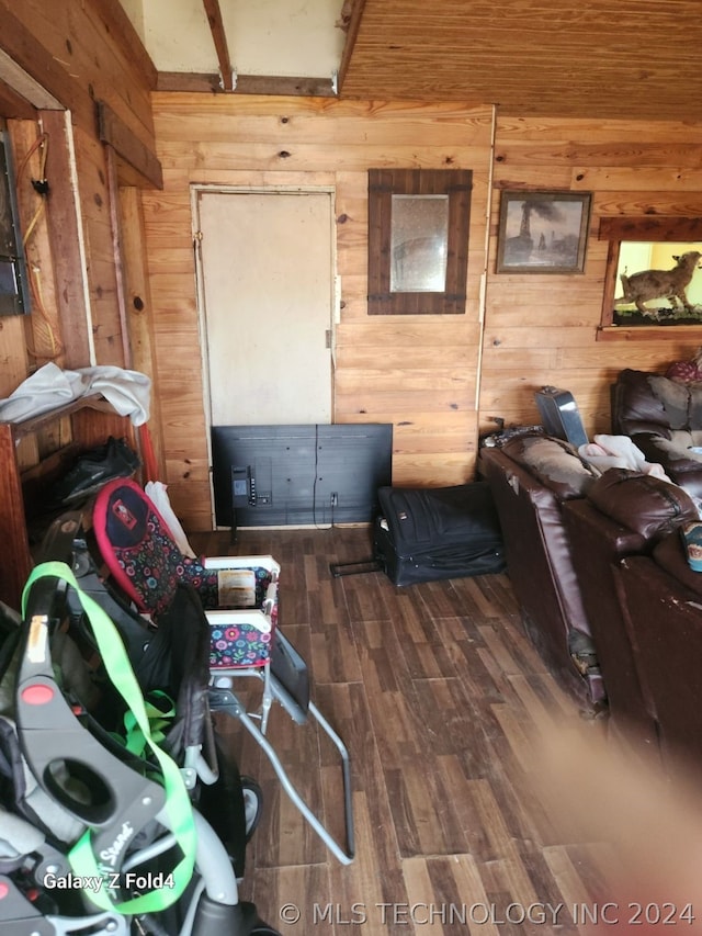 living room with dark wood-type flooring and wood walls