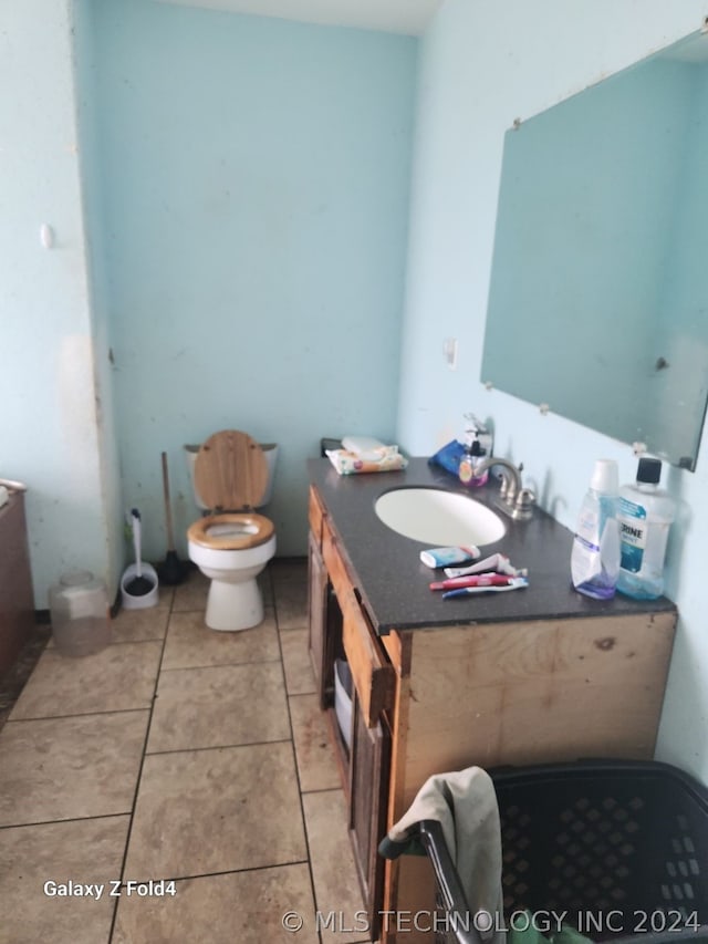 bathroom with tile patterned flooring, vanity, and toilet