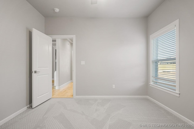 unfurnished bedroom with light carpet, ceiling fan, and baseboards