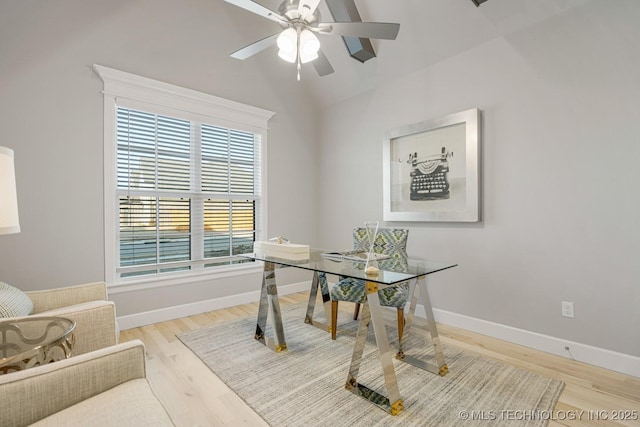 office area featuring a ceiling fan, baseboards, vaulted ceiling, and wood finished floors