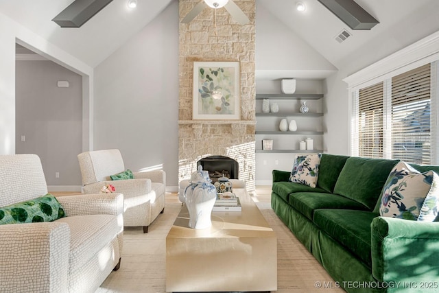 living room featuring a fireplace, visible vents, a ceiling fan, and wood finished floors