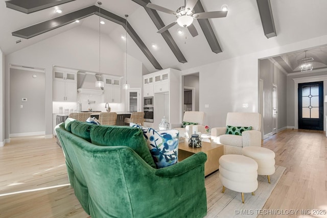 living area featuring high vaulted ceiling, light wood finished floors, beamed ceiling, and baseboards