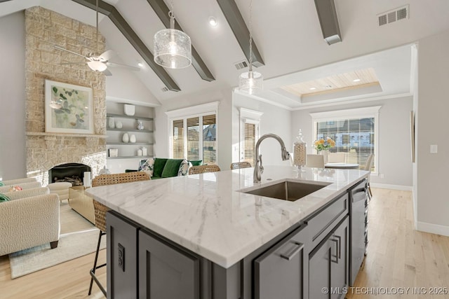 kitchen with open floor plan, a sink, visible vents, and dishwasher