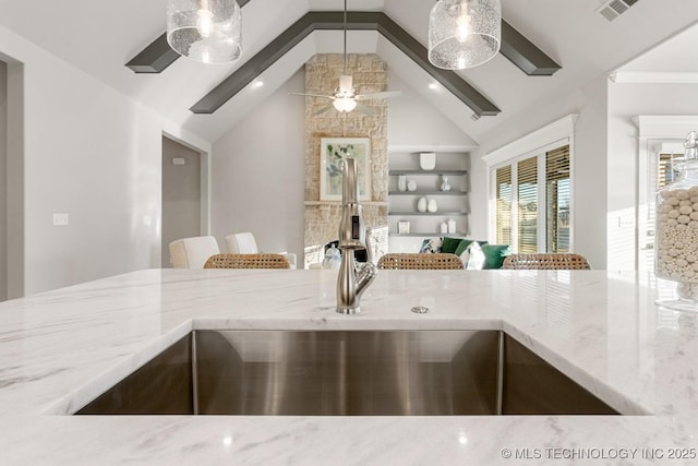 interior space featuring visible vents, light stone counters, ceiling fan, and a sink