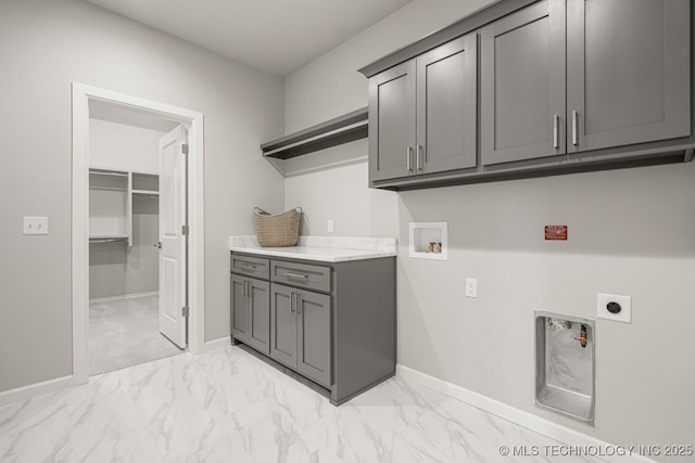 clothes washing area with washer hookup, marble finish floor, cabinet space, electric dryer hookup, and baseboards