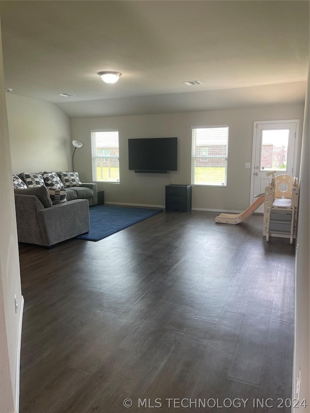 unfurnished living room with plenty of natural light and dark hardwood / wood-style floors