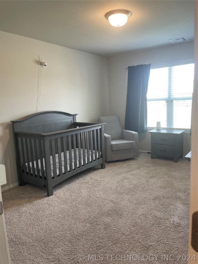 carpeted bedroom with a nursery area