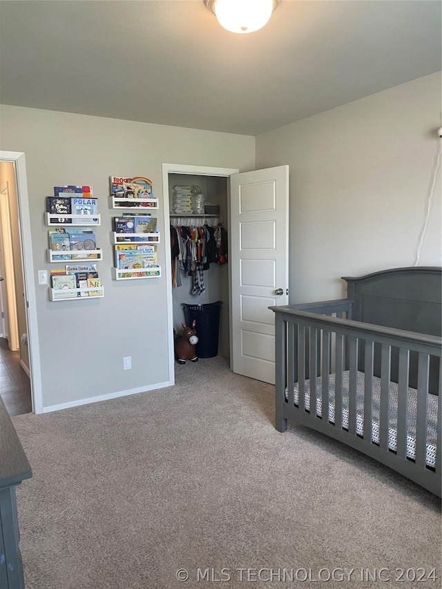 carpeted bedroom featuring a nursery area and a closet