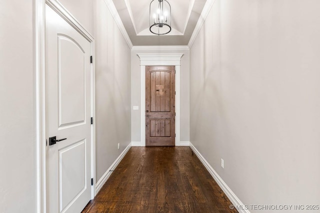 entryway featuring a notable chandelier, a tray ceiling, ornamental molding, and dark hardwood / wood-style floors