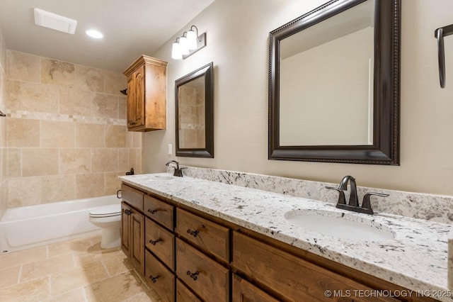 full bathroom with tiled shower / bath, vanity, and toilet