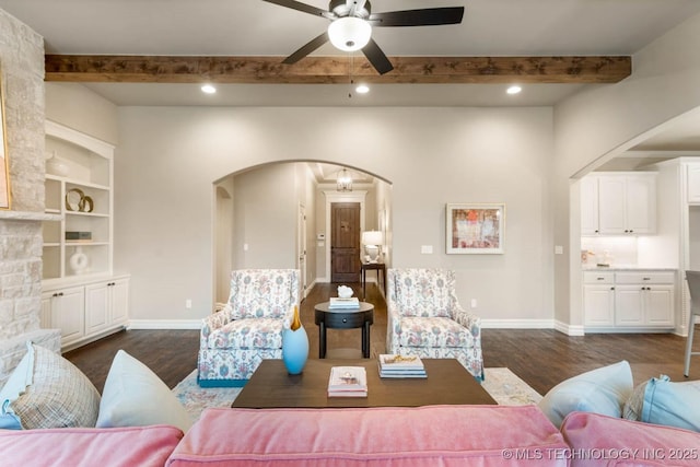 living room with beamed ceiling, ceiling fan, built in features, and dark hardwood / wood-style flooring